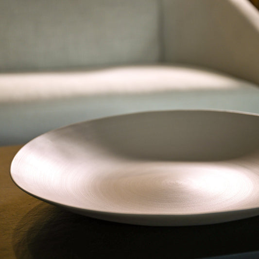 Shell plate large light brown minimalist ceramic bowl with smooth slightly reflective surface and subtle concentric ridges