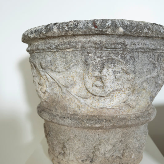 Decorative stone basin with intricate carvings on a white background