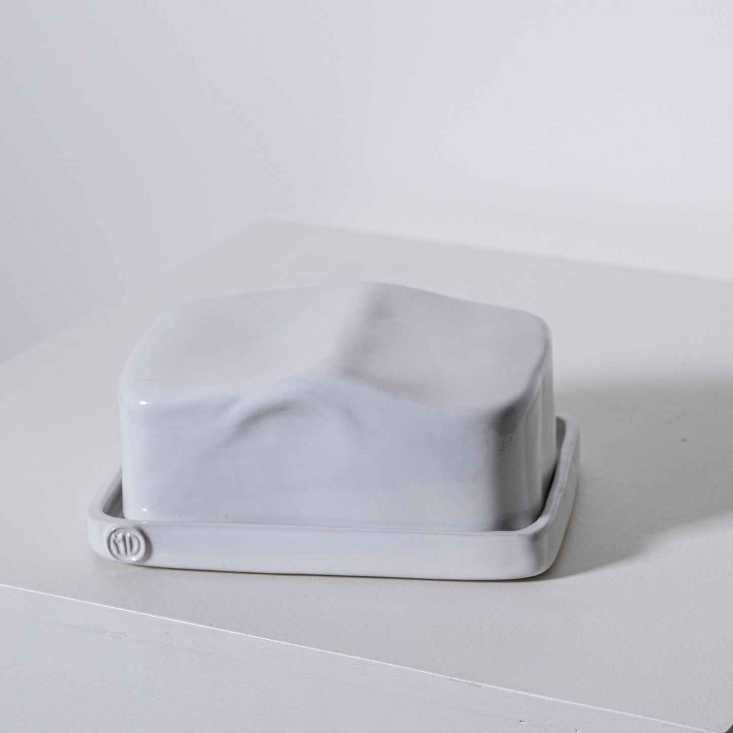 A sleek matte white ceramic european butter dish no 642 with a minimalist rectangular design and rounded edges