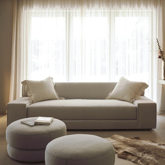 Beige upholstered sectional custom order esme sofa with two matching round ottomans in fabric material
