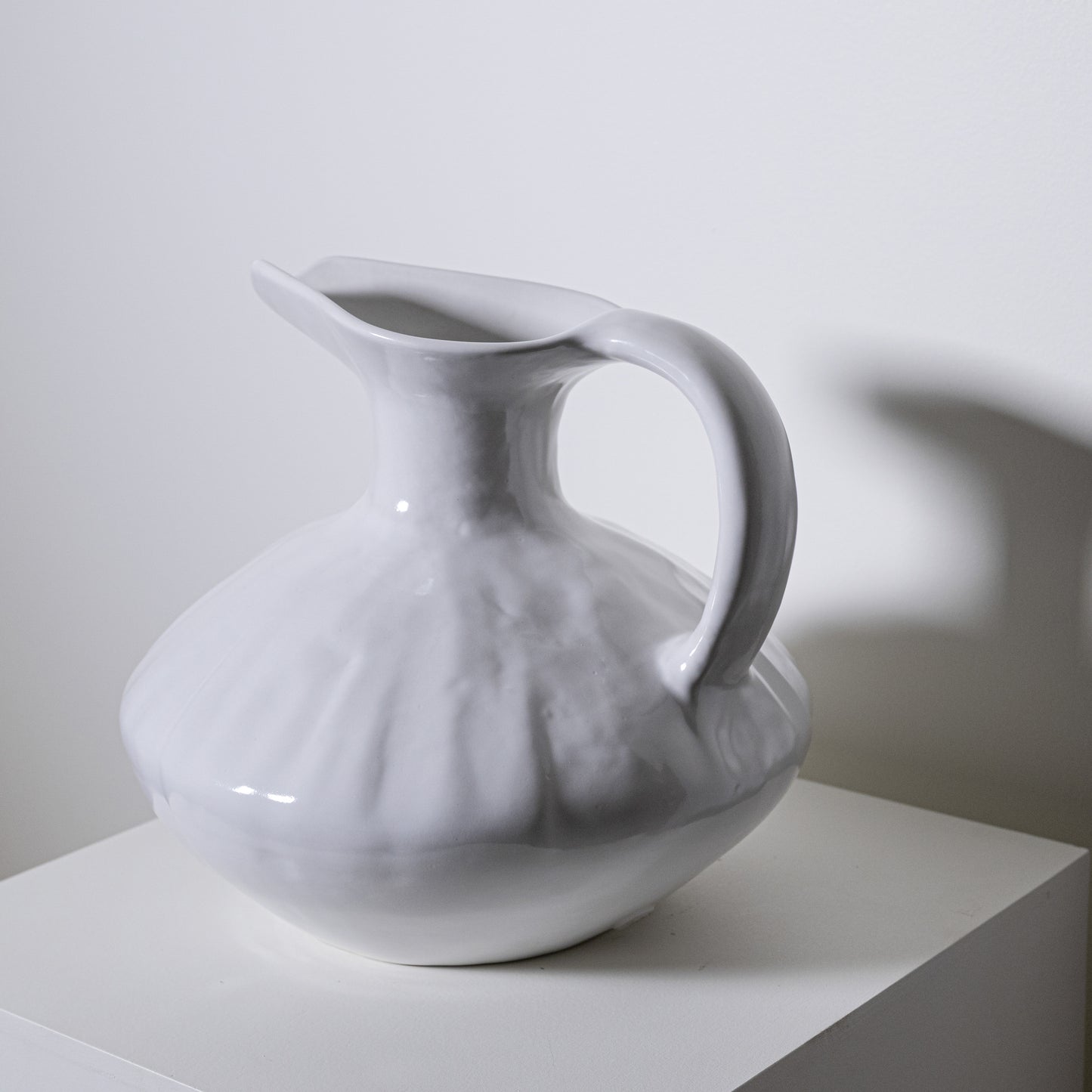 A white ceramic oak pitcher no 431 with a fluted textured body and smooth handle for serving liquids