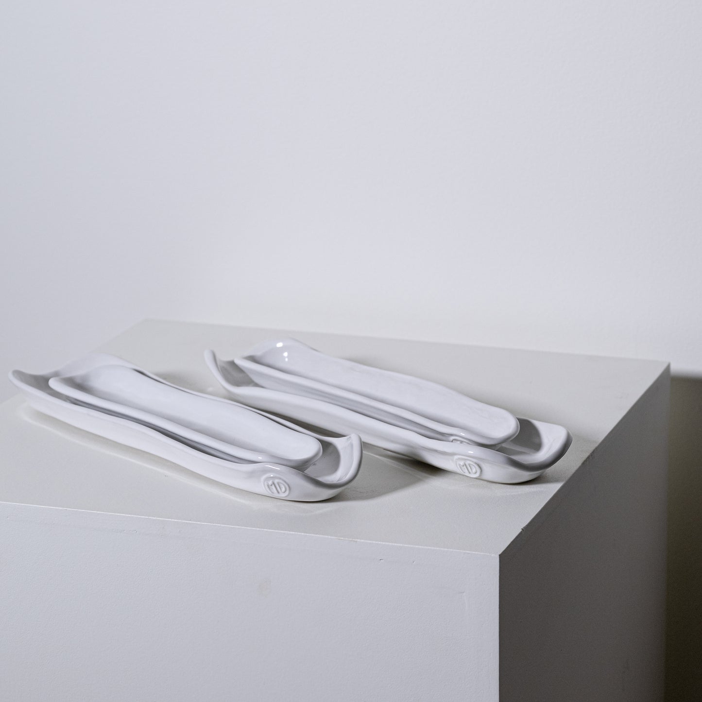 White ceramic olive appetizer plates with sleek modern design and subtle gray accents for serving trays