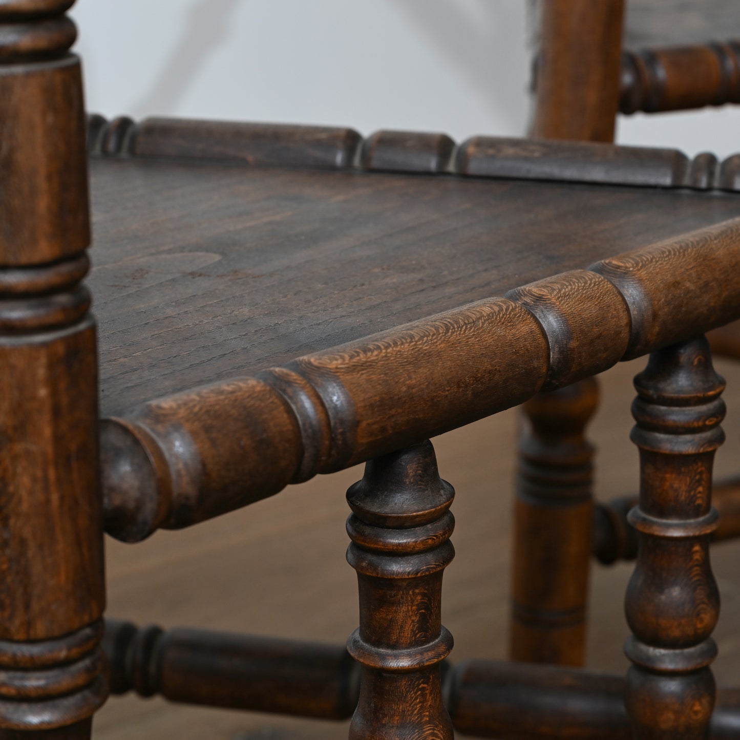 Dark brown wooden early 20th century swedish art deco armchair with turned spindles and worn rustic finish