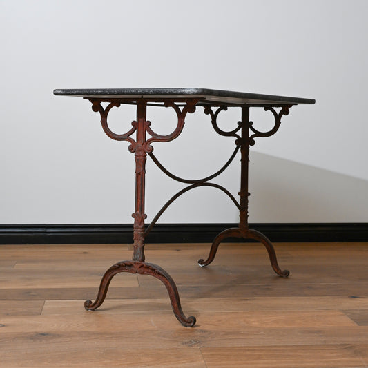 Antique-style 19th century french blue stone garden table with wrought iron scrollwork legs and dark polished marble top