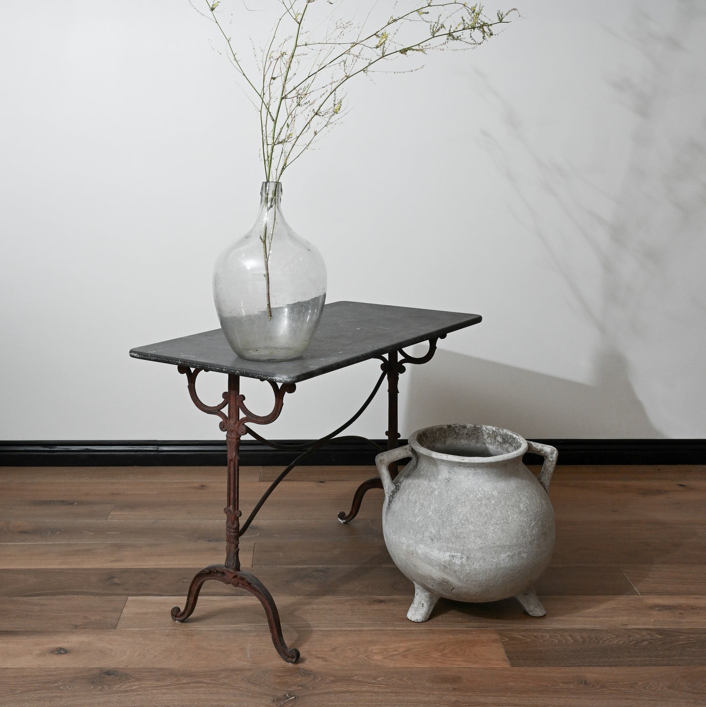 A clear glass mid century willy ghul marmite cauldron vase with a bulbous body and narrow neck holding green branches