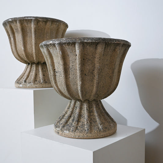 Weathered gray 20th century french fluted concrete garden urns with ribbed surfaces and sturdy pedestals