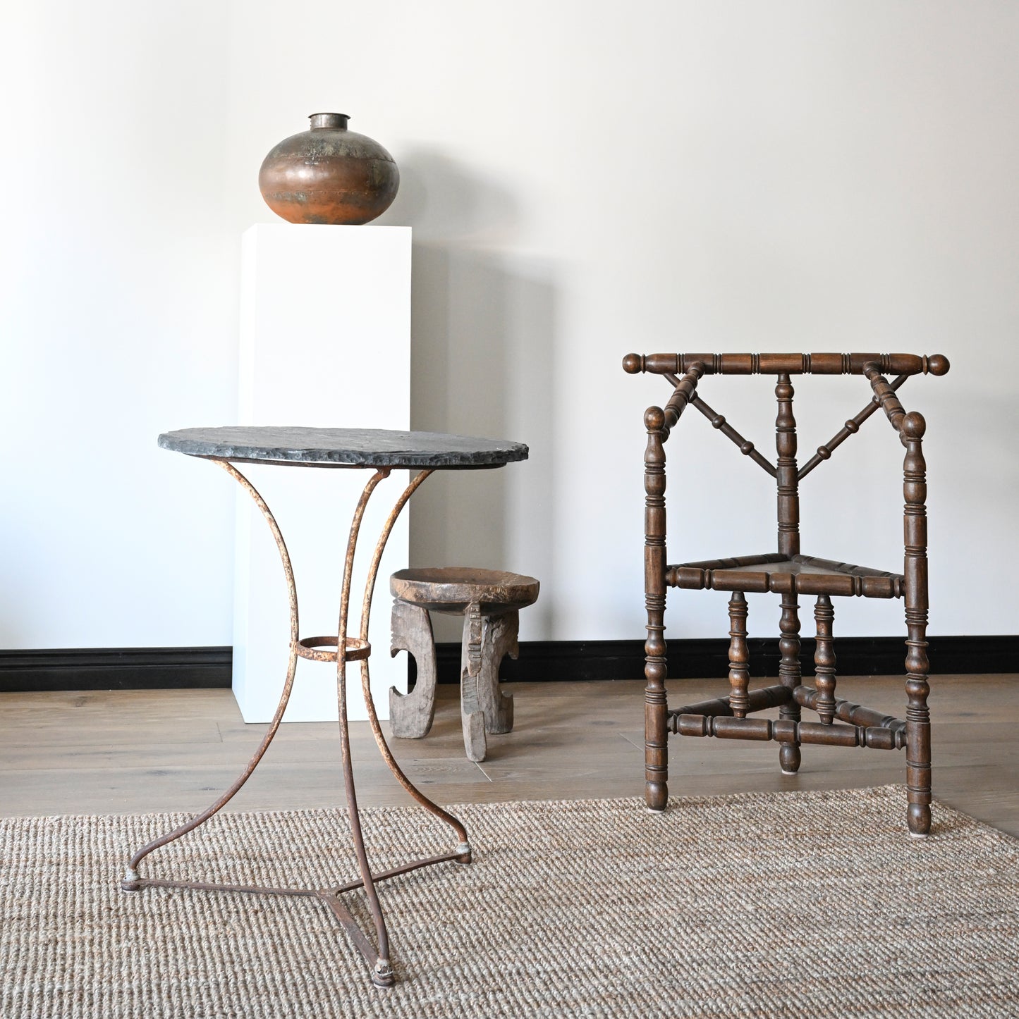 Antique wooden chair with turned spindles and dark brown finish paired with antique French slate bistro table