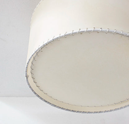 Cream-colored parchment flushmount with cylindrical lampshade featuring textured finish and silver-toned stitched trim