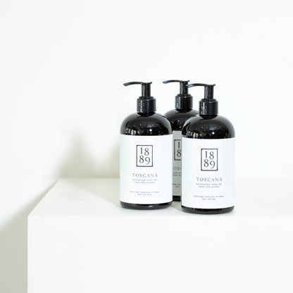 Three black bottles with white labels on a white background