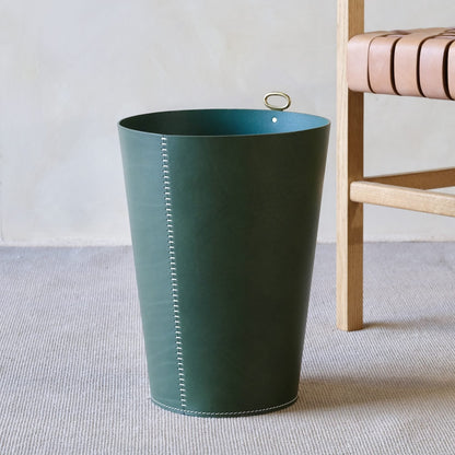 Dark green leather eyelet wastepaper bin with white stitching and gold tone handle for stylish trash disposal
