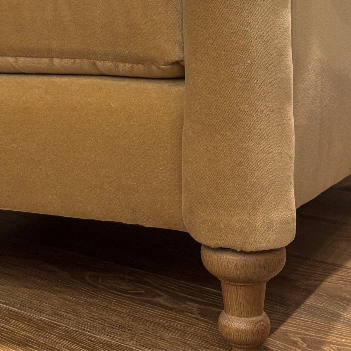 Tan velvet custom order margot club chair leg with turned wooden foot showing detail of the furniture base