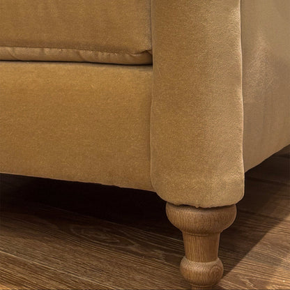 Tan velvet custom order margot club chair leg with turned wooden foot showing detail of the furniture base
