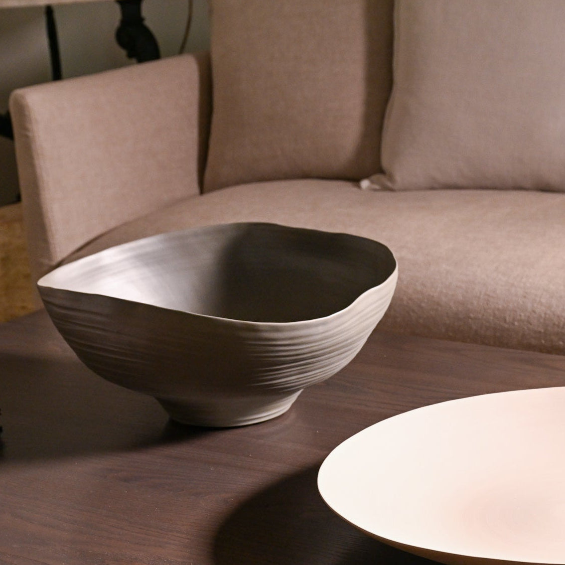 A sleek matte gray ceramic bowl fonte medium moss with textured ribbed exterior and organic asymmetrical shape