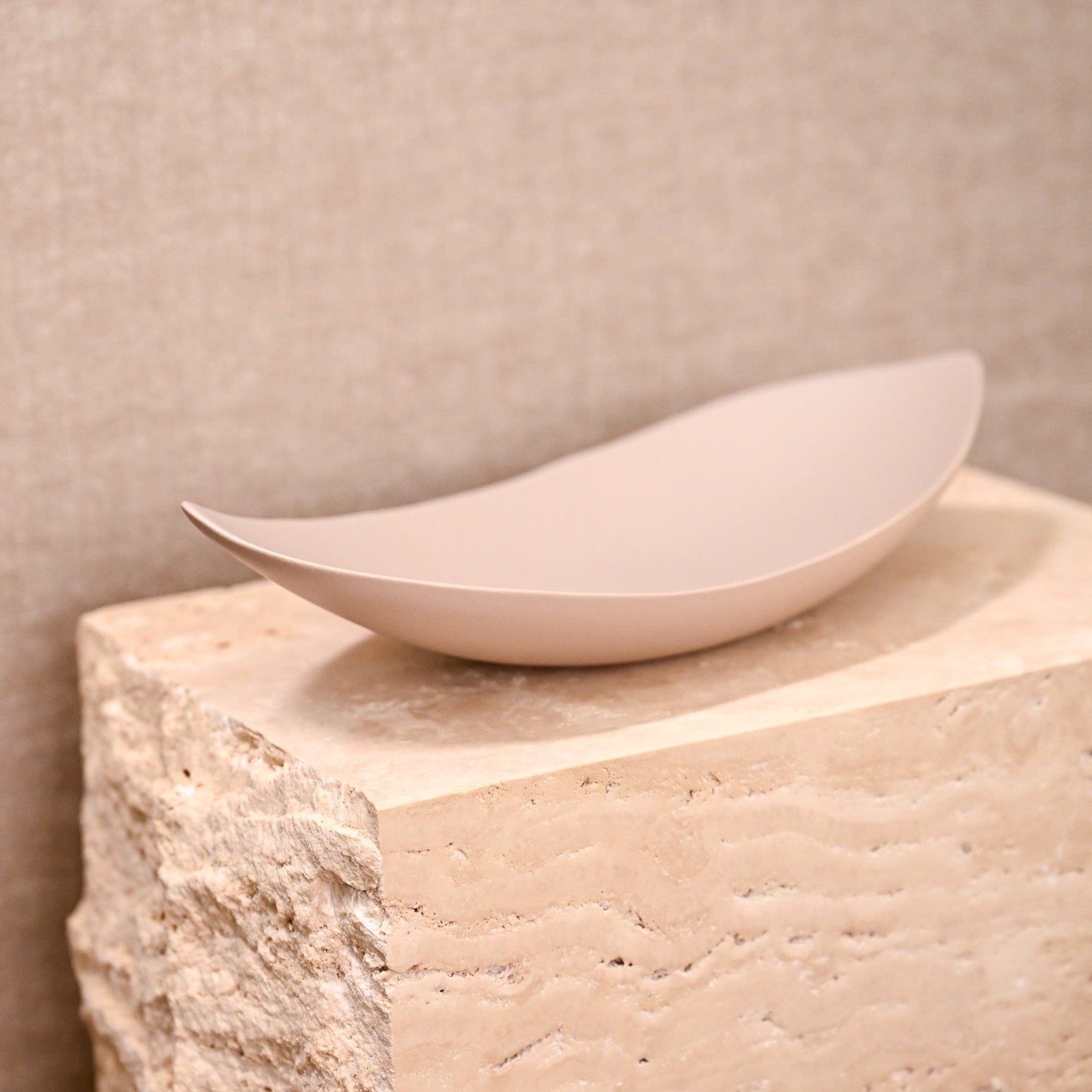 A sleek matte finished off-white ceramic bowl barchetta strette small turtledove with smooth elongated oval shape