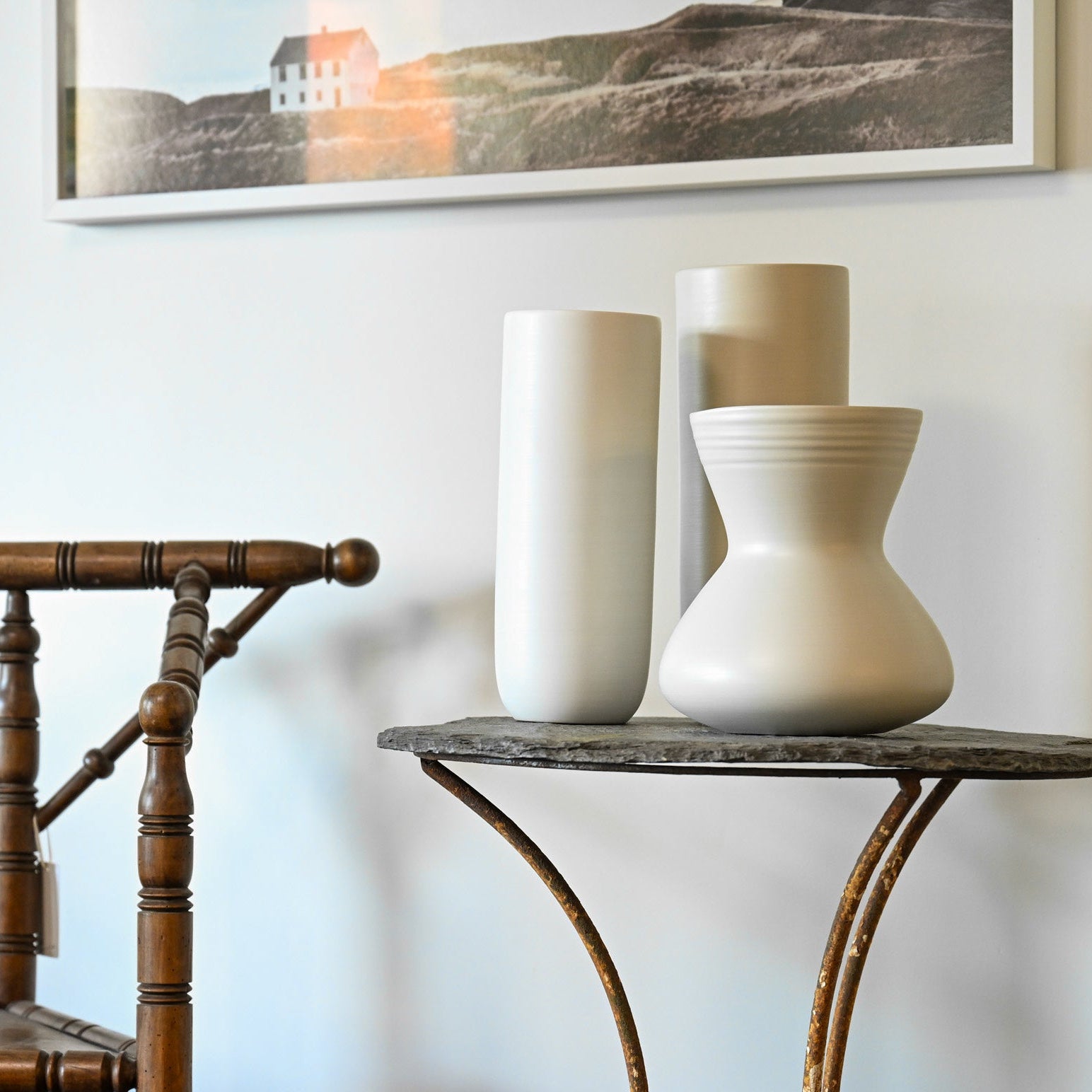 Cream-colored ceramic vases with smooth minimalist design on dark stone tabletop for giare small linen collection