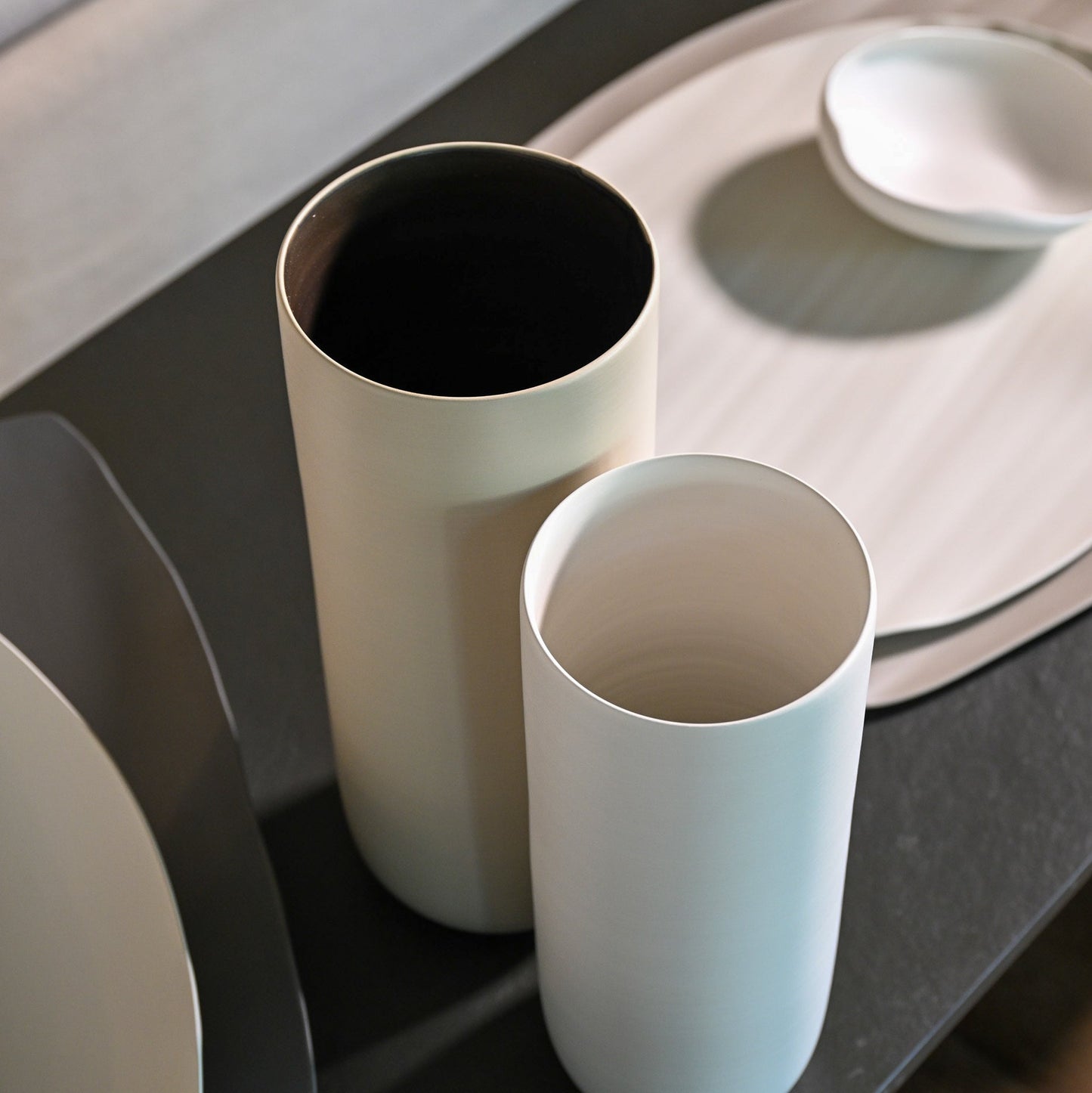 Two minimalist ceramic vases canna wide medium in crème and pale blue with smooth matte finish and dark interiors