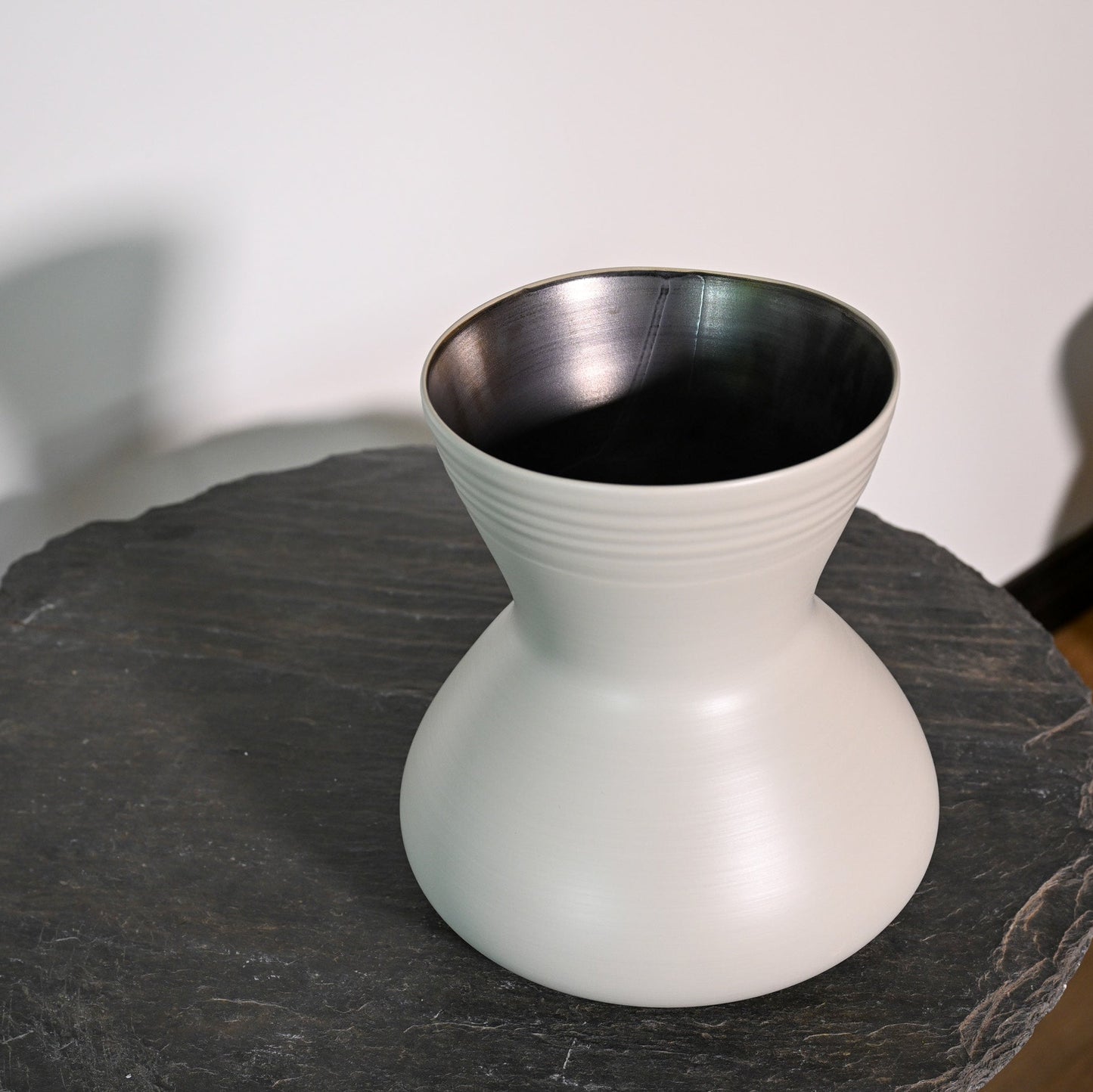 A sleek matte white ceramic giare small linen vase with a flared top and subtle horizontal ridges around its neck