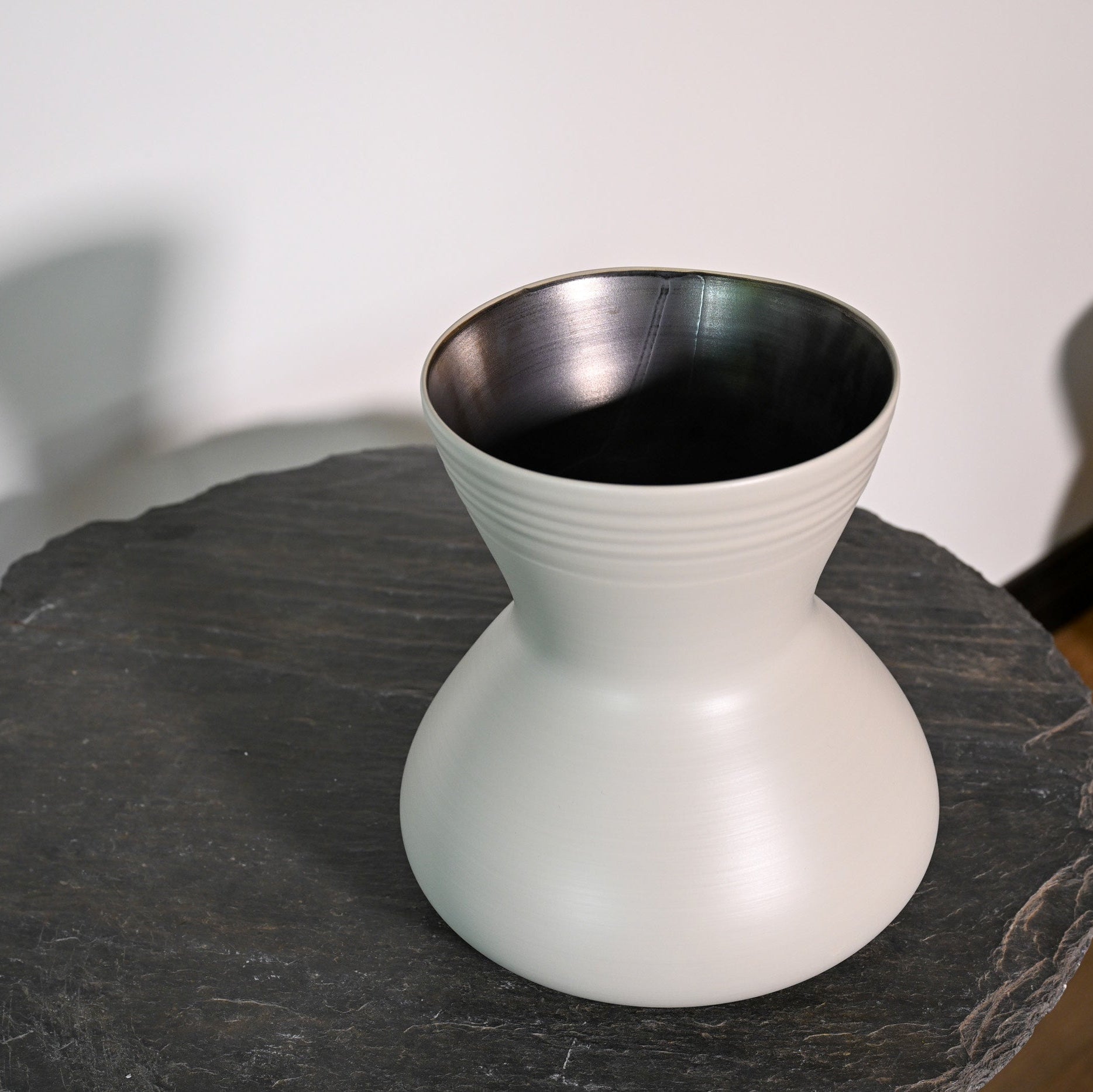 A sleek matte white ceramic giare small linen vase with a flared top and subtle horizontal ridges around its neck
