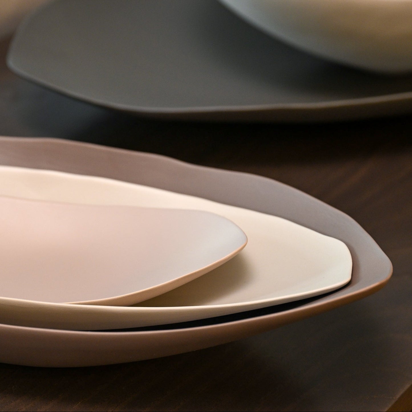 Stacked barchetta strette medium linen ceramic plates with soft muted tones and gently curved edges