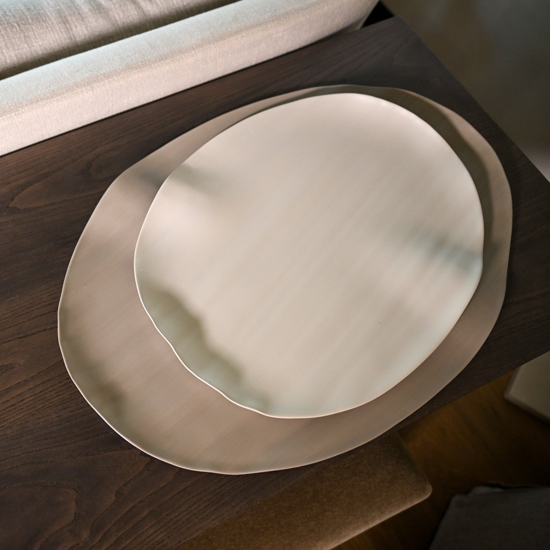 Cream-colored ceramic leaf large linen plates with organic irregular edges and a matte finish for dining