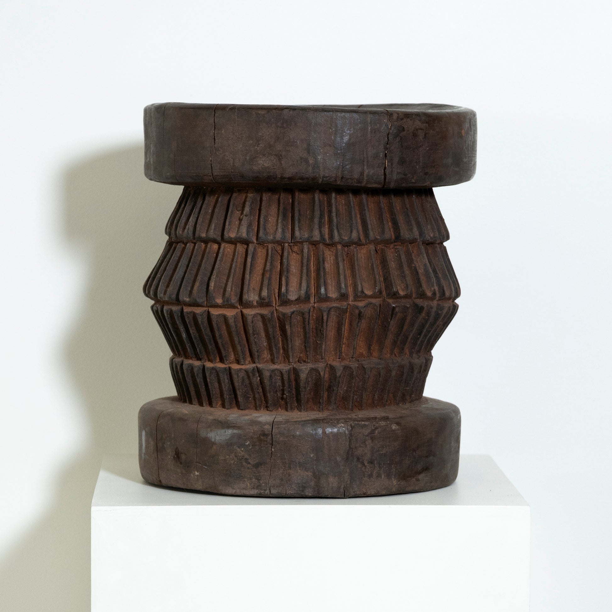 Wooden stool with a textured design on a white background