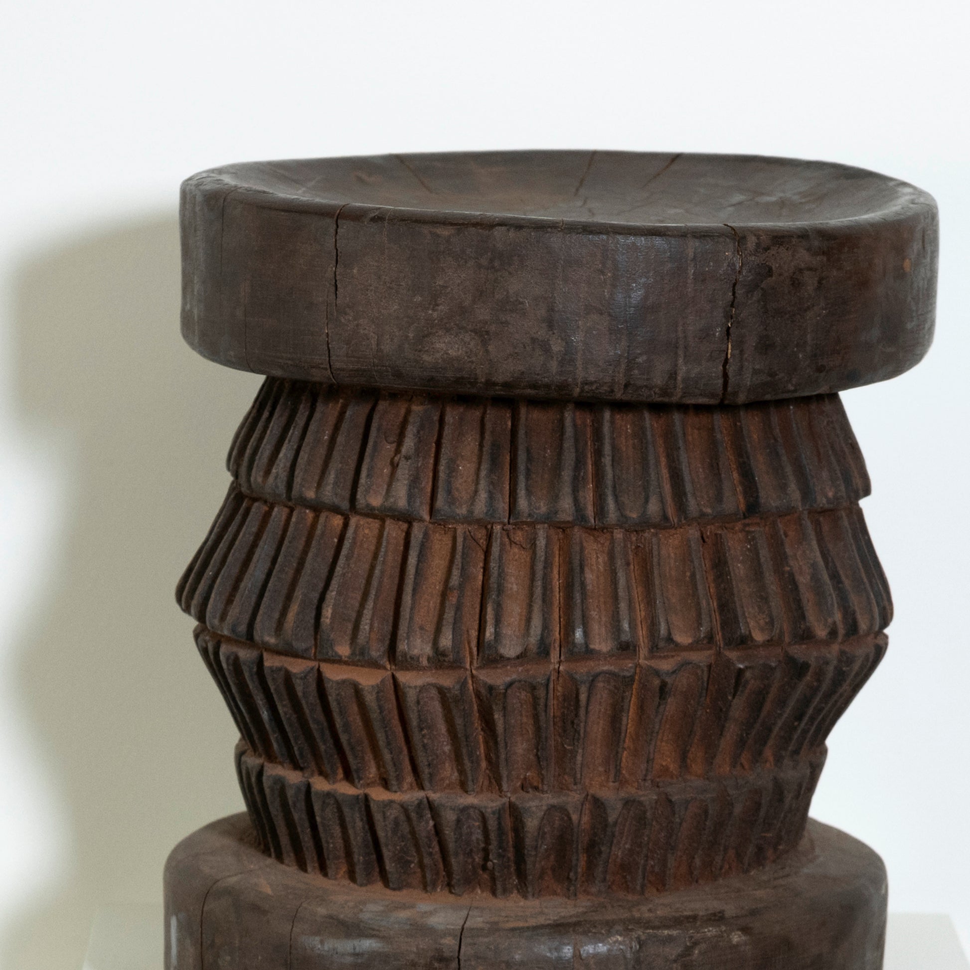 Wooden stool with a textured design on a white background