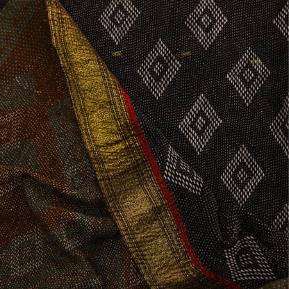 Close-up of a black and brown patterned blanket with white geometric diamond motifs.