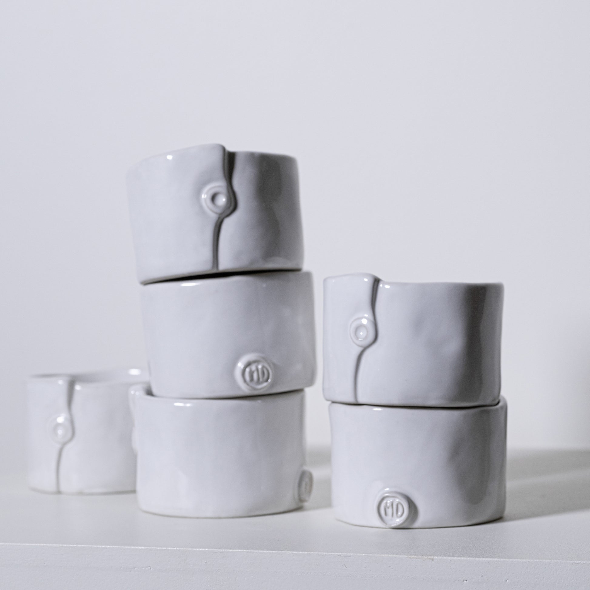 Gray ceramic ring holders with subtle button detail and embossed md logo from birch ramekins no 241 collection