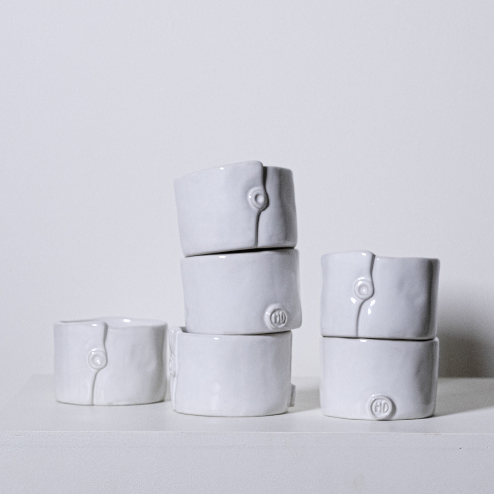 White ceramic ring-shaped napkin rings with subtle button detail and embossed hd logo from birch ramekins no 241