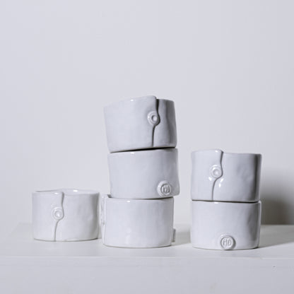 White ceramic ring-shaped napkin rings with subtle button detail and embossed hd logo from birch ramekins no 241