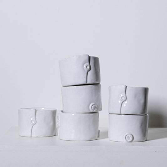 White ceramic ring-shaped napkin rings with subtle button detail and embossed hd logo from birch ramekins no 241