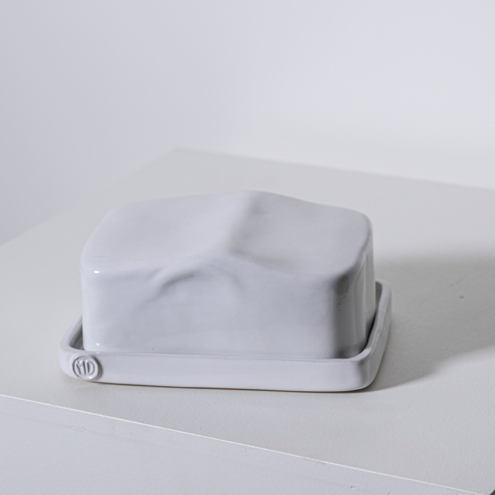 A sleek matte white ceramic european butter dish no 642 with a minimalist rectangular design and rounded edges