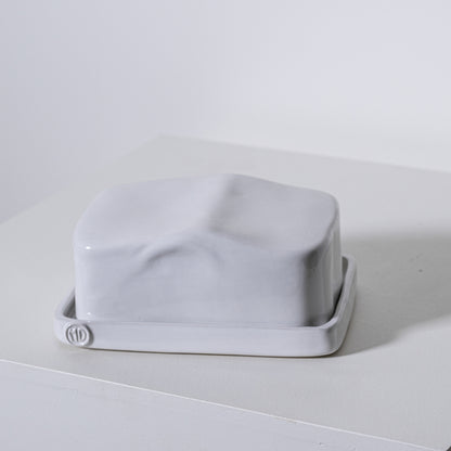 A sleek matte white ceramic european butter dish no 642 with a minimalist rectangular design and rounded edges