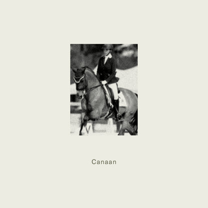 A black-and-white photo of a rider in formal equestrian attire on a dark horse for maison d’etto candle canaan