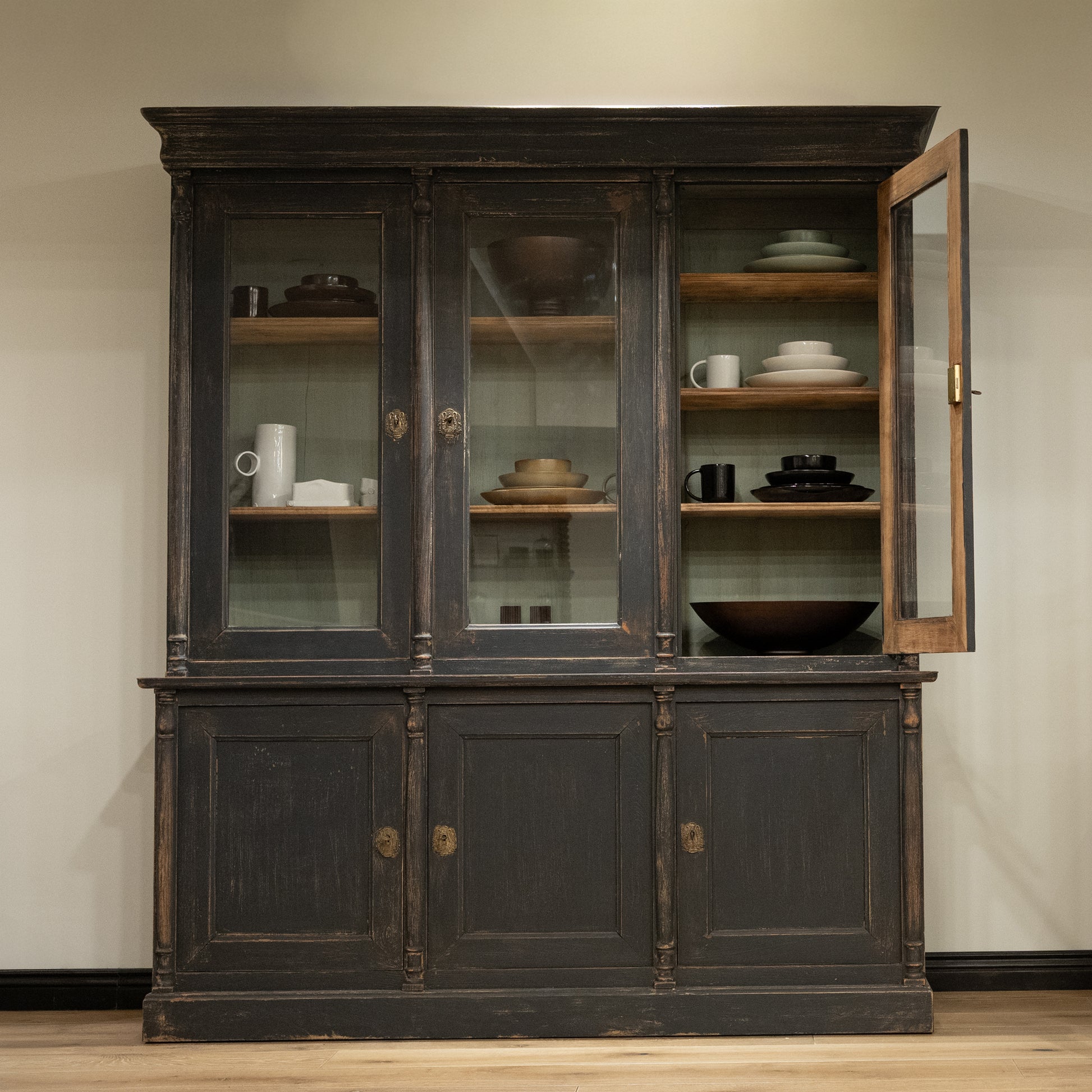 Late 19th century French display cabinet with dark gray distressed wood, glass doors, and brass hardware