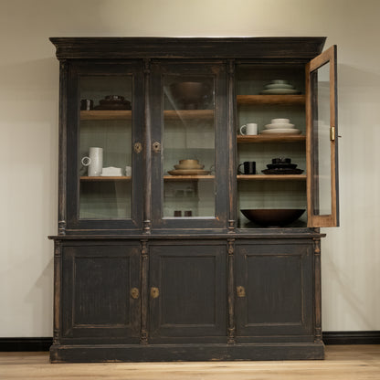 Late 19th century French display cabinet with dark gray distressed wood, glass doors, and brass hardware