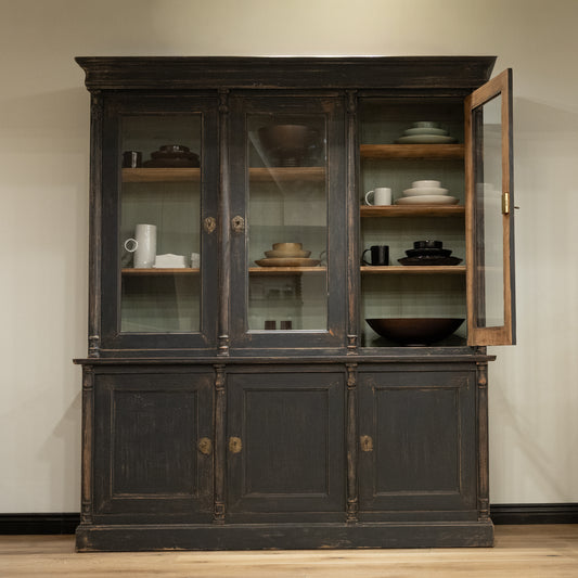 Late 19th century French display cabinet with dark gray distressed wood, glass doors, and brass hardware