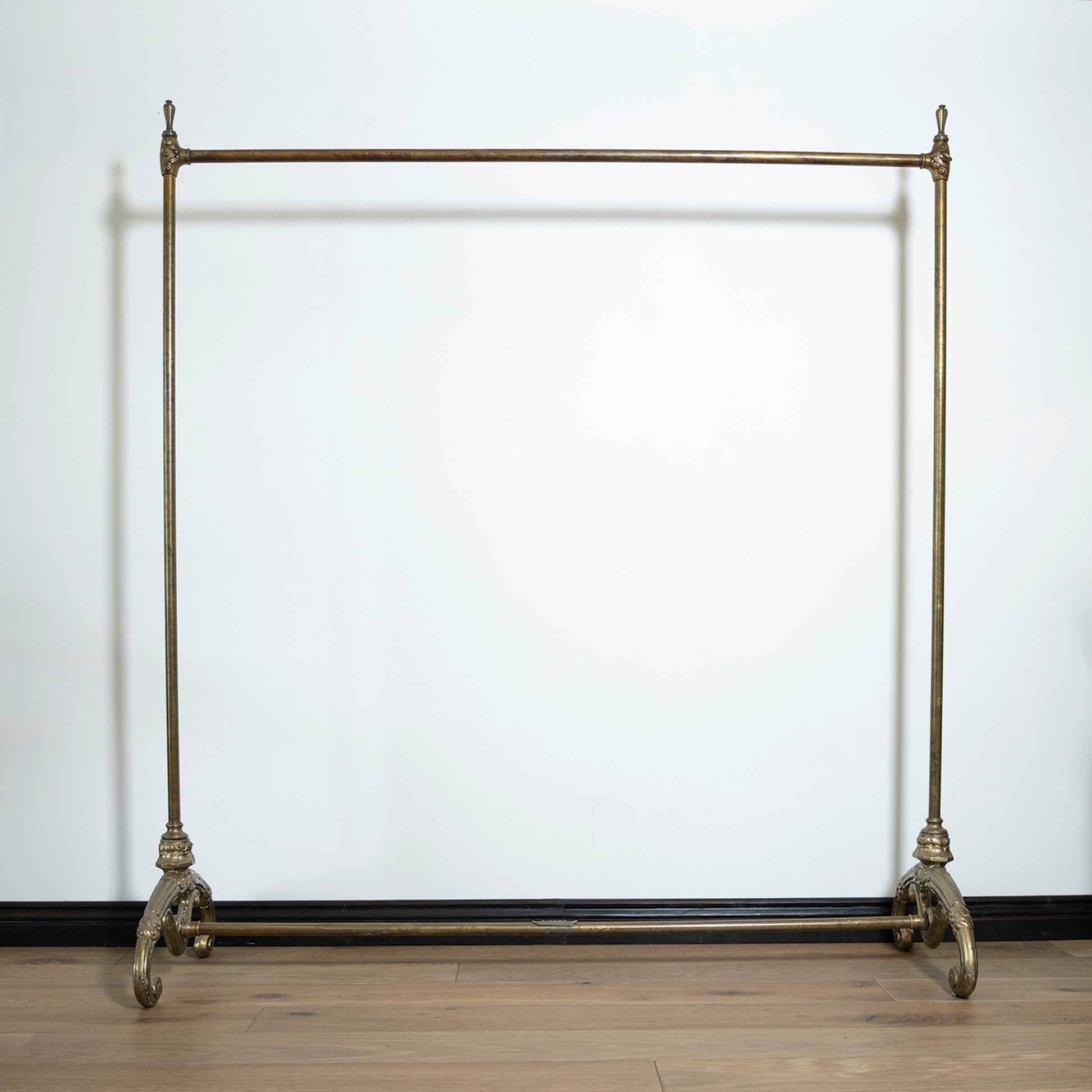 Vintage-style metal garment rack against a white wall.