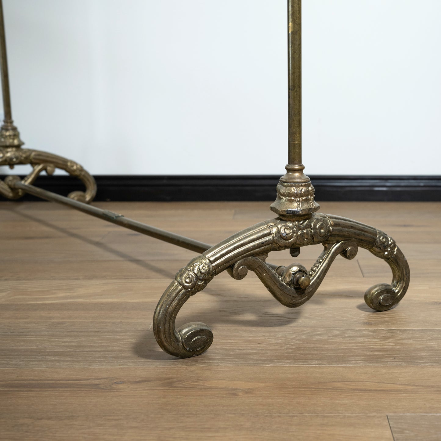 Decorative metal rack with intricate designs on a wooden floor.