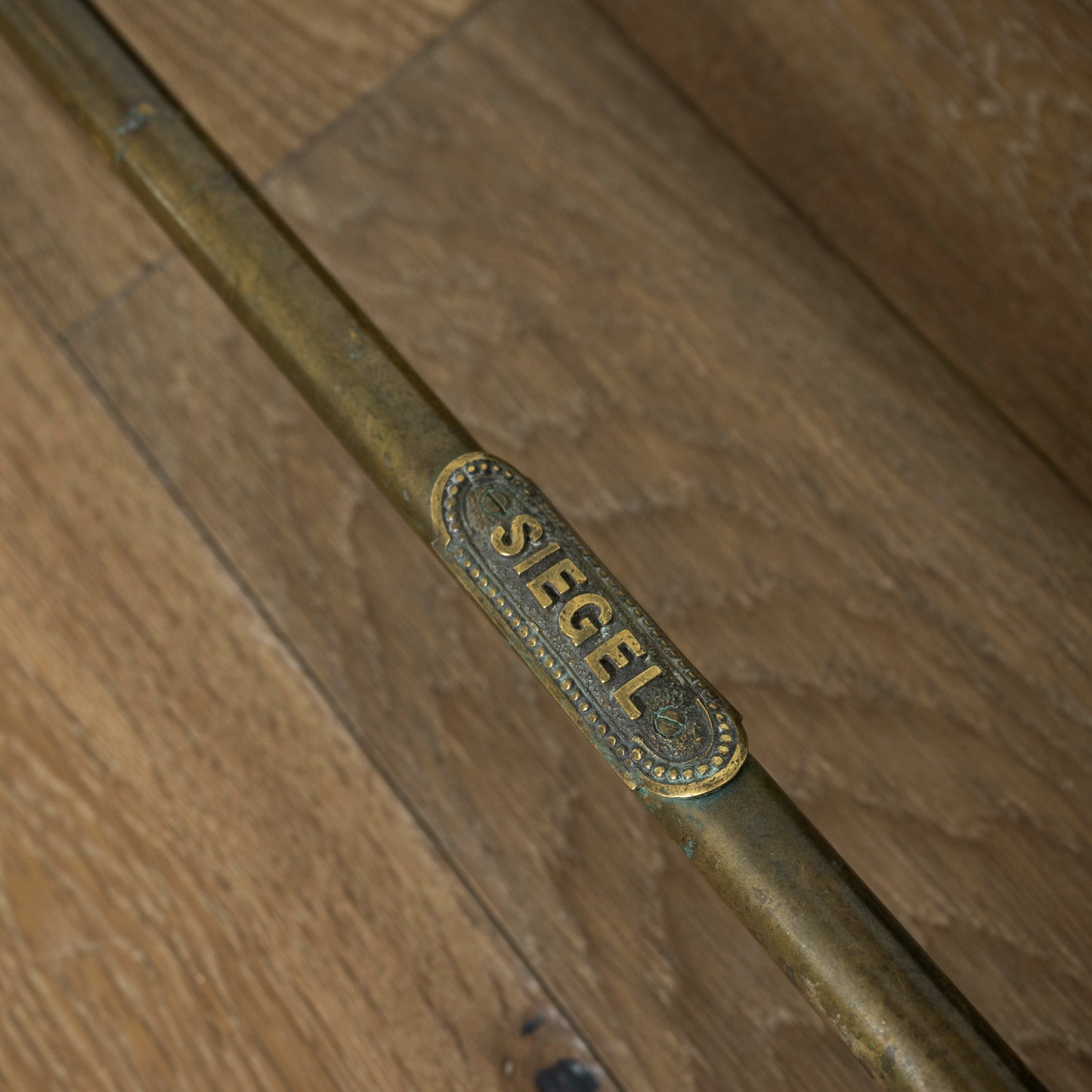 Brass rack with 'SIEGEL' engraving on a wooden door