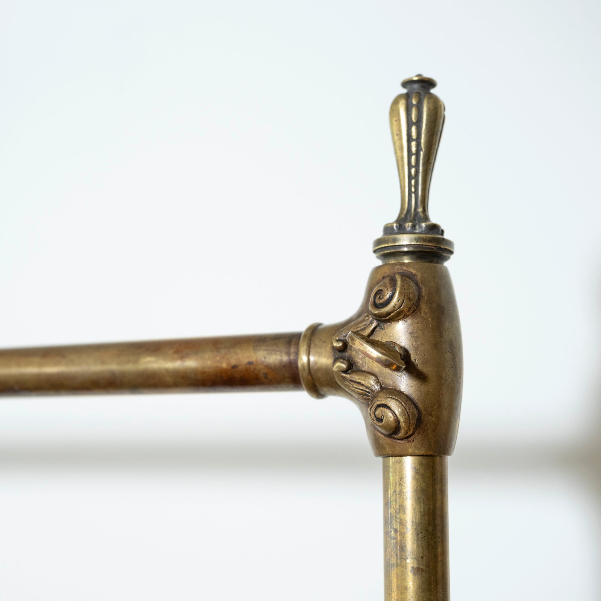 Close-up of an ornate brass stand with decorative elements on a white background