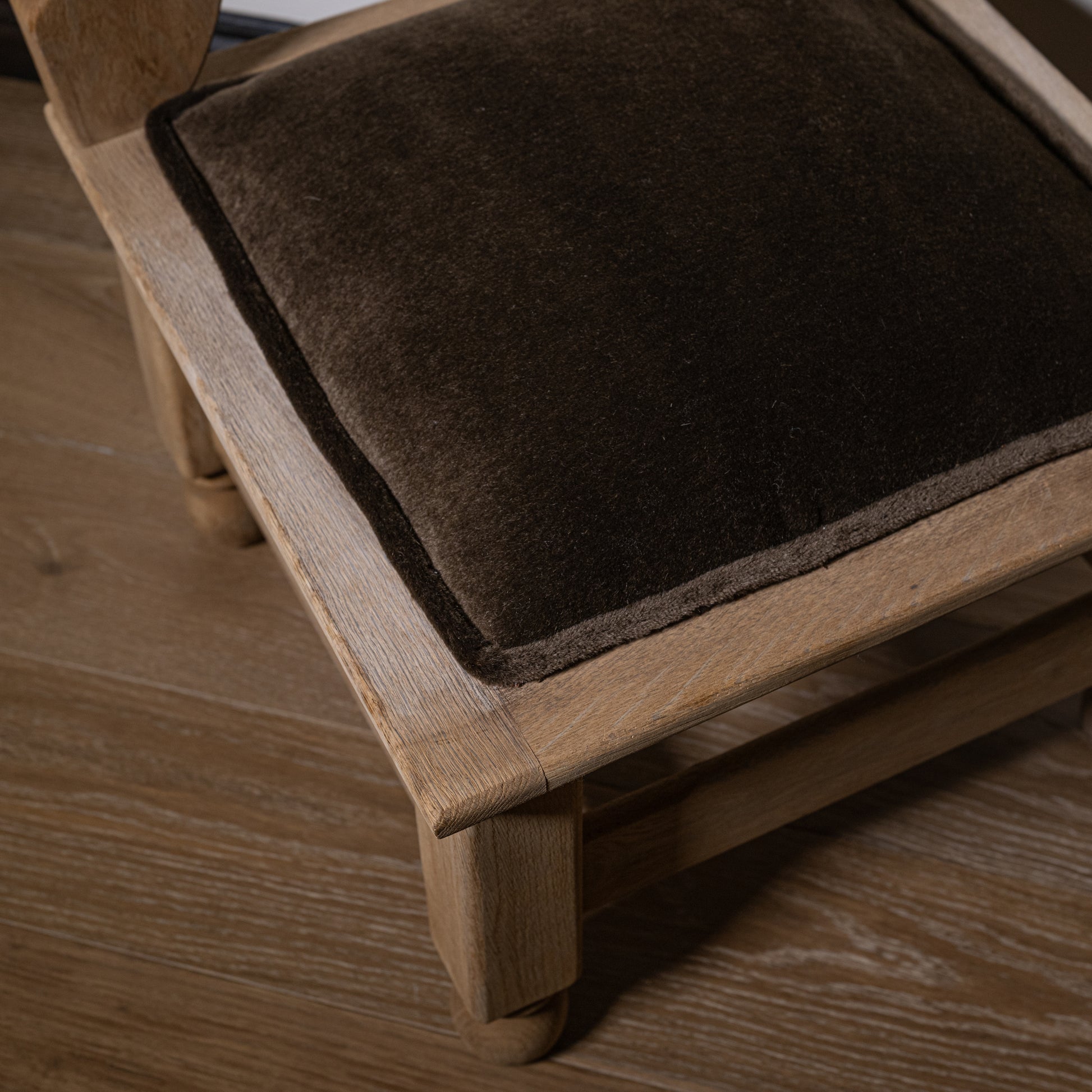Carved wood corner stool with a dark brown velvet mohair seat set in a light oak wooden frame