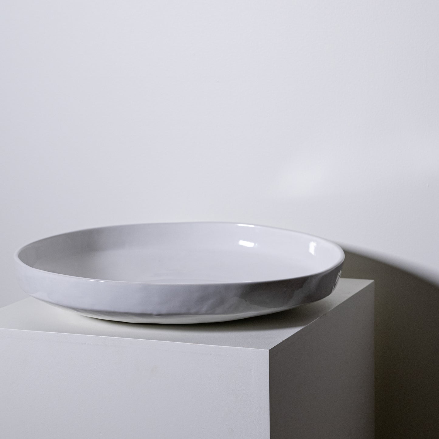 A minimalist white ceramic cottonwood platter no 316 with a smooth glossy finish and subtle textured rim