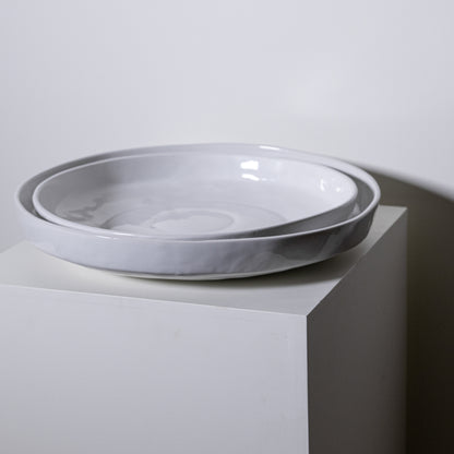 Two nested white ceramic bowls with subtle gray marbled rims displayed on a minimalist pedestal in cottonwood platter no 316