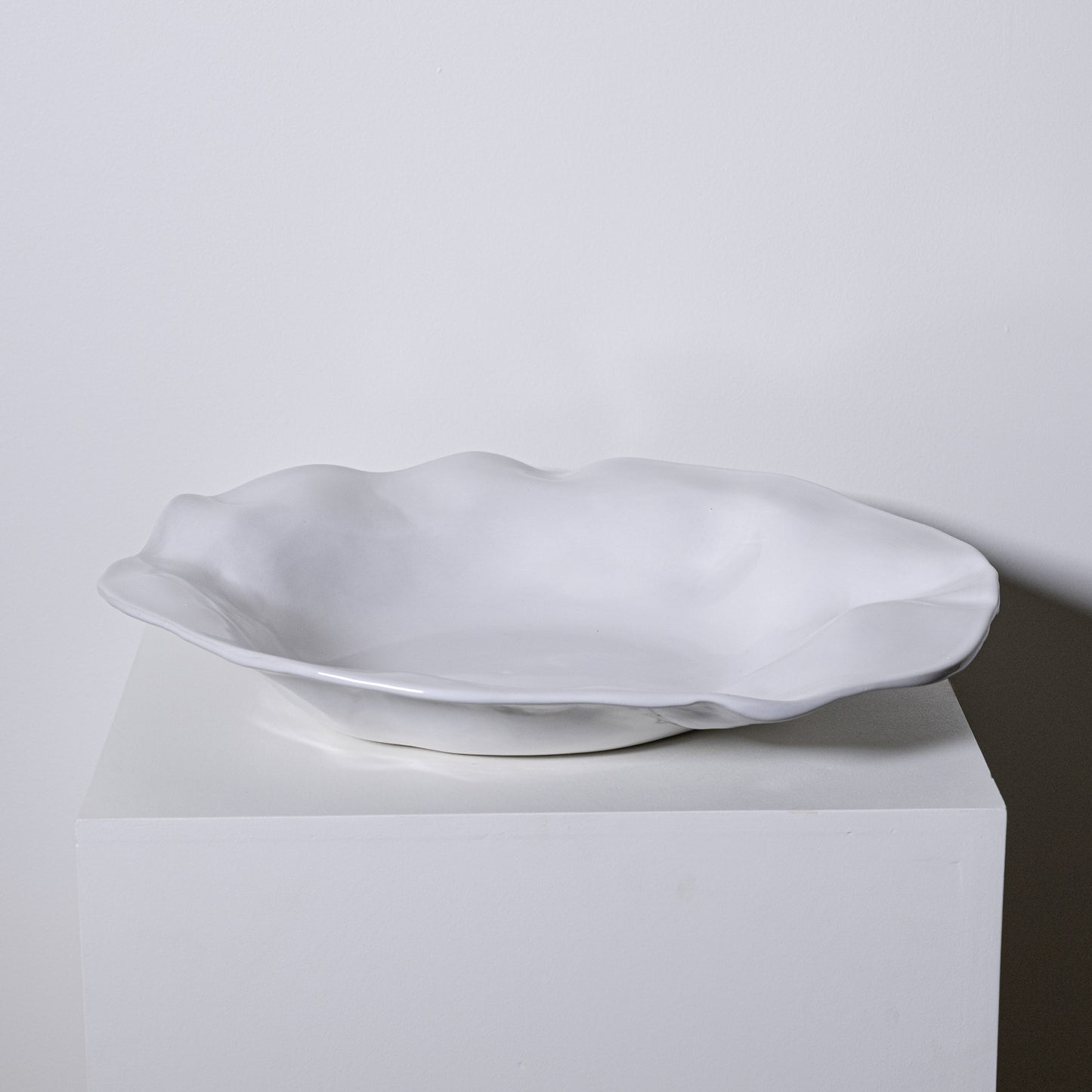 A white ceramic Cyprus platter no 724 with a smooth glossy finish and an organic wavy rim