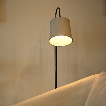 Minimalist brass and leather floor lamp with matte white cylindrical shade and slender black metal pole