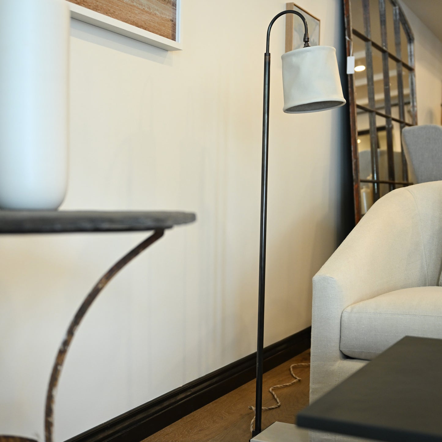 Black metal floor lamp with white fabric shade featuring brass and leather accents for elegant lighting