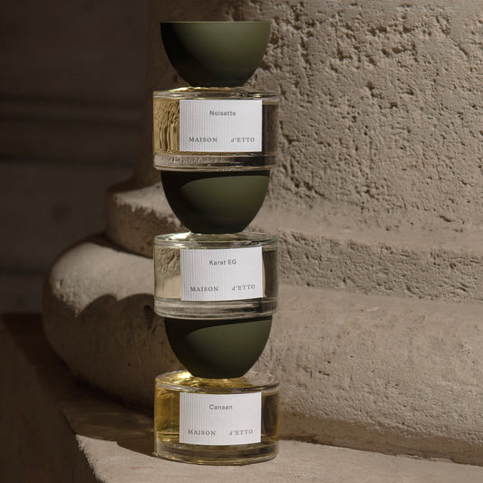 Stacked glass perfume bottles from maison d etto with matte olive green caps and minimalist white labels for karat eg fragrance