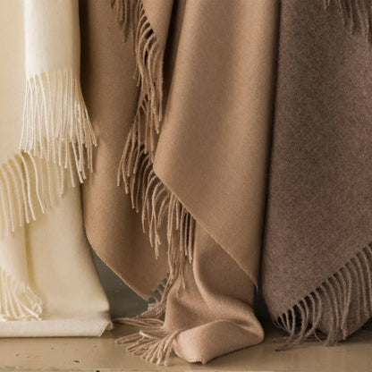 Three soft alpaca plaid wool throws in pearl olive colors with matching fringed edges for cozy use