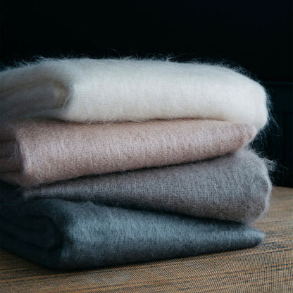Stack of four soft fluffy mohair scarves in neutral tones including off-white blush pink gray and charcoal for cozy wear